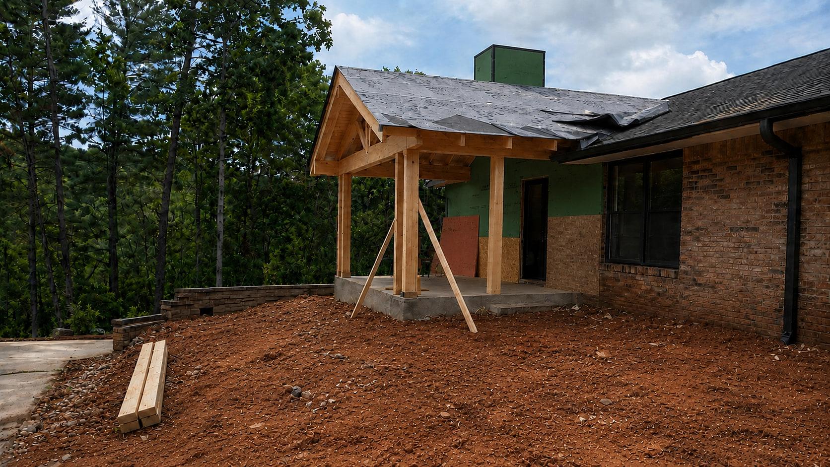 The same entry during construction: exposed framing, house wrap and bare graded soil before finishes went on