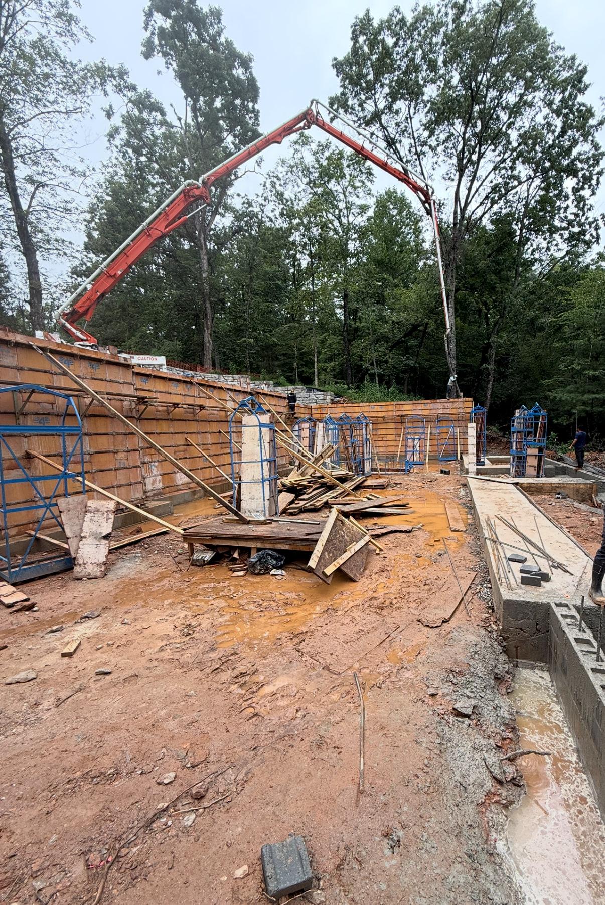 Concrete pump truck placing a poured foundation wall on a new build